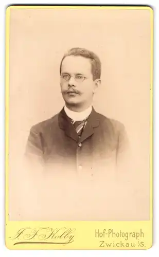 Fotografie J. F. Kolby, Zwickau i. S., Kaiser Wilhelm-Platz 31, Herr im Anzug mit Brille und Schnurrbart