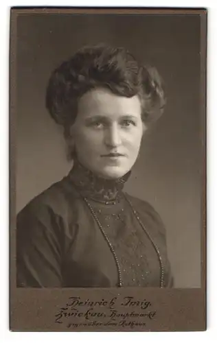 Fotografie Heinrich Imig, Zwickau, Hauptmarkt 15, Junge Dame im schwarzen Kleid mit langer Perlenkette blickt nach oben