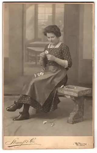 Fotografie Strauss & Co., Wien, junge Frau zählt Blütenblätter, Blumenorakel, Er liebt mich, er liebt mich nicht, 1912