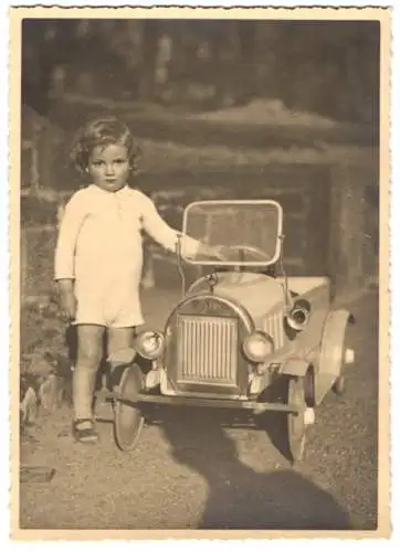 Fotografie Tretauto Cebaso, niedliches Kind mit Spielzeug-Blechauto