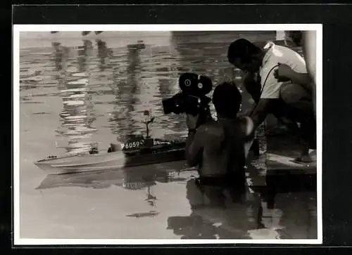 AK Mann mit einer Kamera im Wasser mit einem Modellschiff