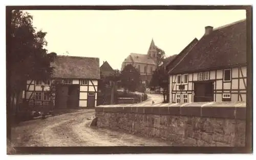 Fotografie unbekannter Fotograf, Ansicht Messinghausen, Strassenpartie im Ort mit Blick zur Kirche, Fachwerkhäuser