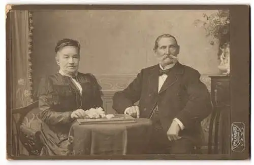 Fotografie Emil Kraemer, Tannwald, Josef und Beata Naumann in feiner Garderobe am Tisch