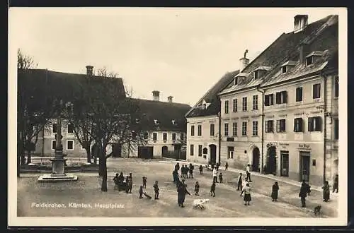 AK Feldkirchen /Kärnten, Hauptplatz mit Friseurgeschäft Hans Ettinger und Denkmal