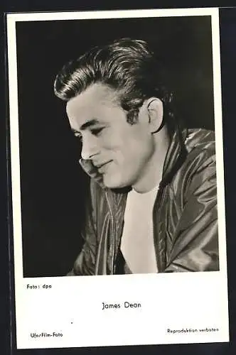 AK Schauspieler James Dean mit schwarzer Jacke zur Seite lächelnd