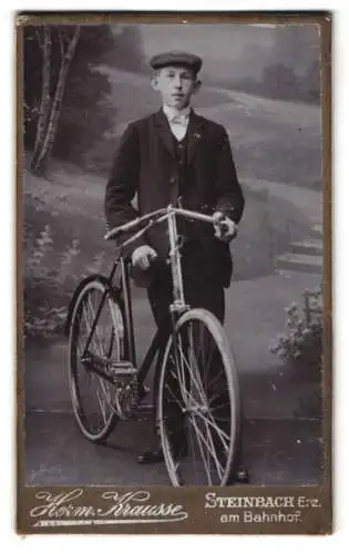 Fotografie Herm. Krausse, Steinbach i. Erzg., junger Mann mit seinem Fahrrad vor einer Studiokulisse