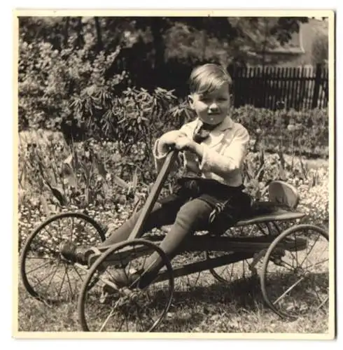 Fotografie Knabe sitzt im Draisinen - Tretauto, Spielzeug-Auto, Seifenkiste