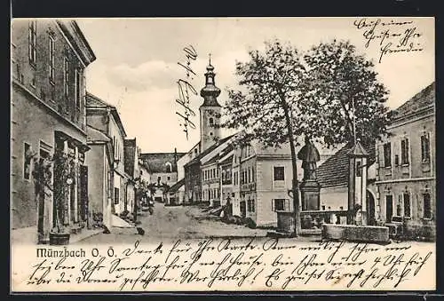 AK Münzbach /O. Ö., Strassenpartie mit Denkmal und Kirche