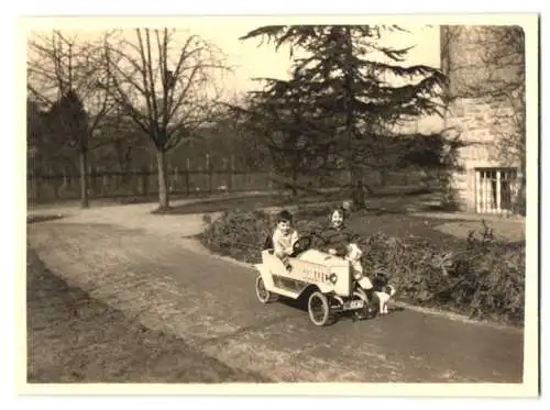 Fotografie Knaben spielen mit Tretauto, Seifenkiste, Spielzeug-Auto