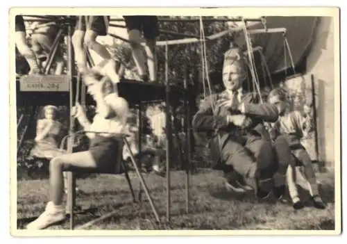 Fotografie Rummel - Kirmes, Mann mit Fes im Kinderkarussell sitzend