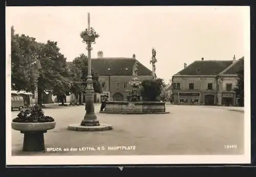 AK Bruck an der Leitha, Hauptplatz mit Geschäften und Brunnen