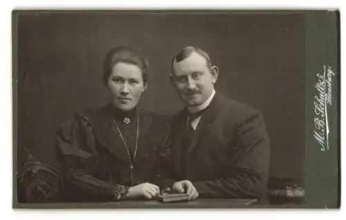 Fotografie M. B. Schultz, Flensburg, Bürgerliches Paar mit Buch am Tisch