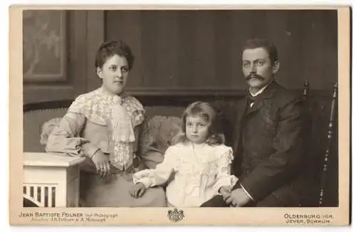 Fotografie Jean Baptiste Feilner, Oldenburg i. Gr., Rosenstr. 29, Ein junges Ehepaar mit ihrer Tochter im weissen Kleid