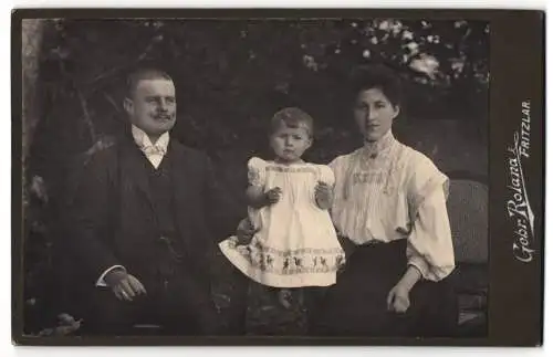 Fotografie Gebr. Roland, Fritzlar, Junges Ehepaar im Sonntagsstaat mit der kleinen Tochter in der Mitte