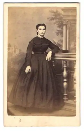 Fotografie K. Hackenjost, Speyer, junge Frau im dunklen taillierten Kleid lehnt an einem Geländer