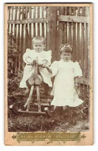 Fotografie Reinh. Börner, Stuttgart, zwei kleine Mädchen in weissen Kleidern auf ihrem Schaukelpferd im Garten