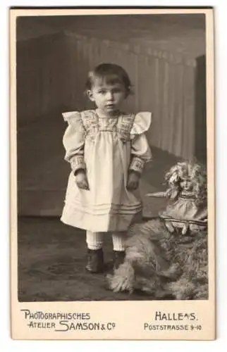 Fotografie Atelier Samson & Co., Halle / Saale, kleines Mädchen im Kleid nebst ihrer Puppe mit Locken