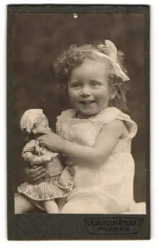 Fotografie Kunstlicht-Atelier, Pforzheim, niedliches Mädchen Trudel mit Locken und ihrer Puppe auf dem Schoss