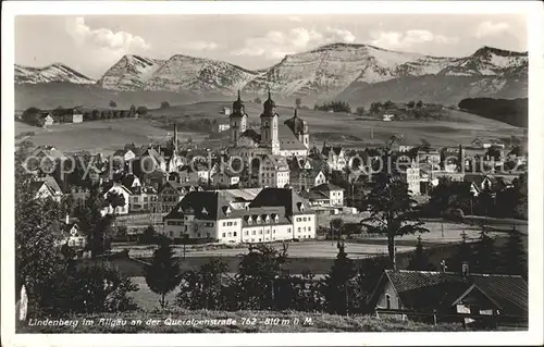 AK / Ansichtskarte Lindenberg Allgaeu Ortsansicht mit Kirche Queralpenstrasse Alpenpanorama Kat. Lindenberg i.Allgaeu