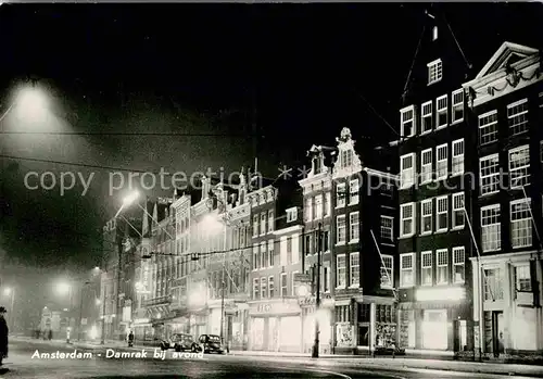 AK / Ansichtskarte Amsterdam Niederlande Damrak bij avond Nachtaufnahme Kat. Amsterdam