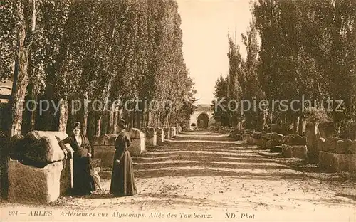 AK / Ansichtskarte Arles Bouches du Rhone Arlesiennes aux Alyscamps Allee des Tombeaux Kat. Arles