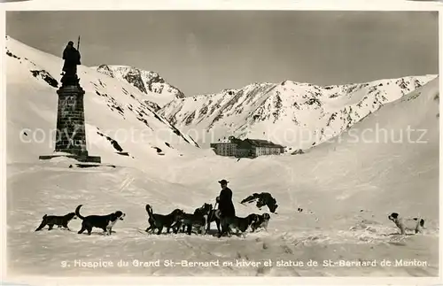 AK / Ansichtskarte Grand_St_Bernard Hospice Mann mit Bernardiner Hunden Statue de St. Bernard de Menton Grand_St_Bernard